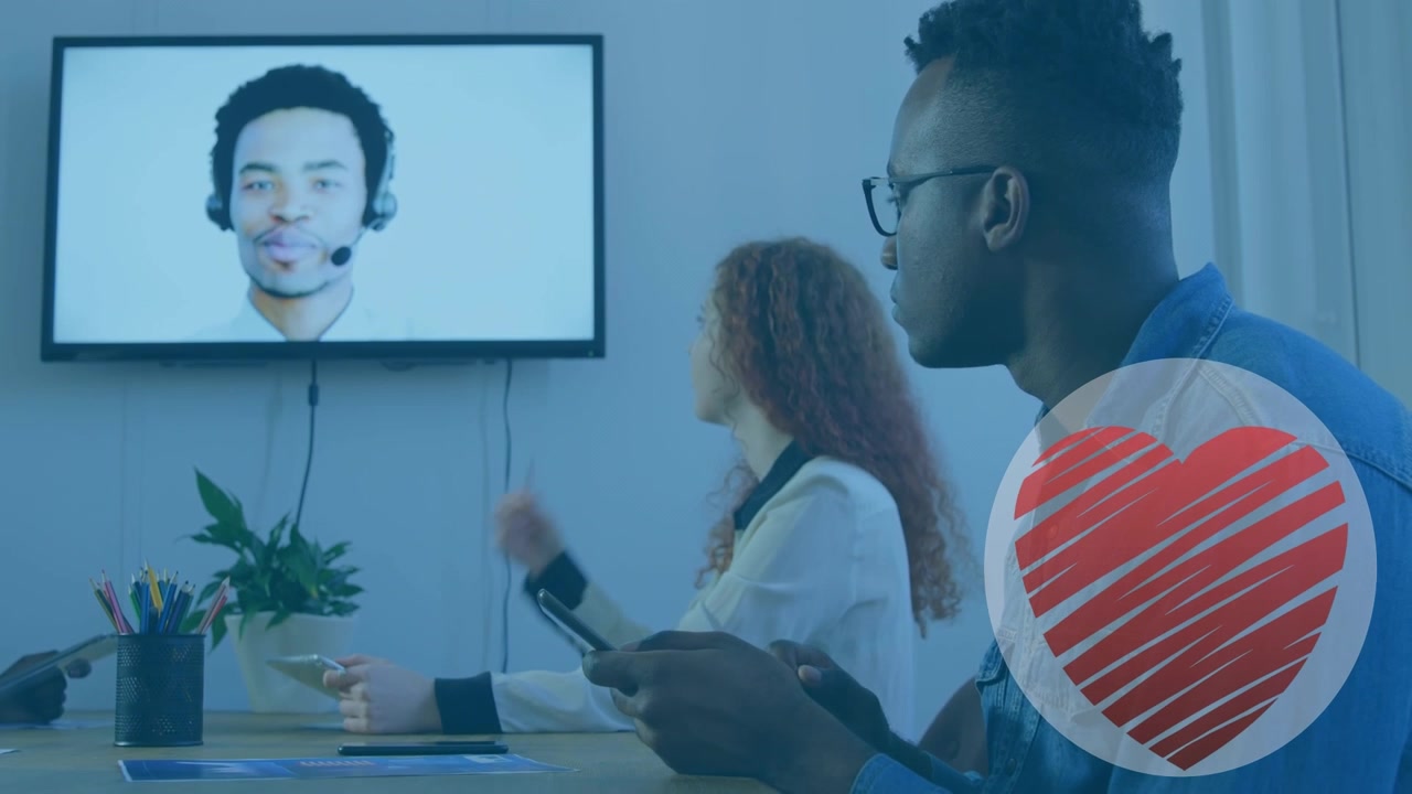 Animation of heart icon over diverse business people talking at meeting