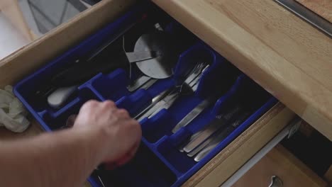 taking the tableware out from the drawer in the kitchen