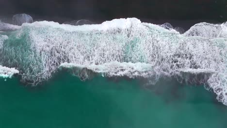 waves crashing black sand boulder rocks rugged coastline usal beach campground lost coast trail california birdseye aerial drone fog mist rain cloudy layers morning pacific ocean upwards motion