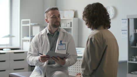 el médico explica el diagnóstico a la paciente durante la consulta en la clínica