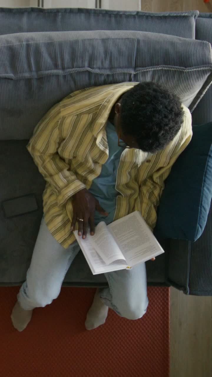Ein Mann liest ein Buch auf einer Couch
