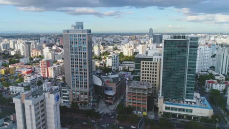 drone circle orbits around high rise residential skyscrapers with santo domingo city center in the background aerial