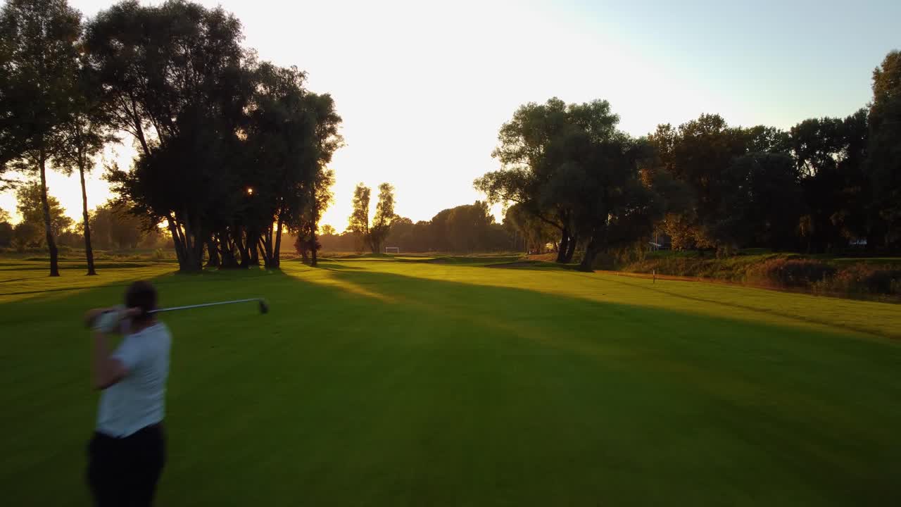 Low Angle Flying Drone Shot with Golf Player Putting Green on Golf Course
