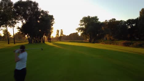 low angle flying drone shot with golf player putting green on golf course