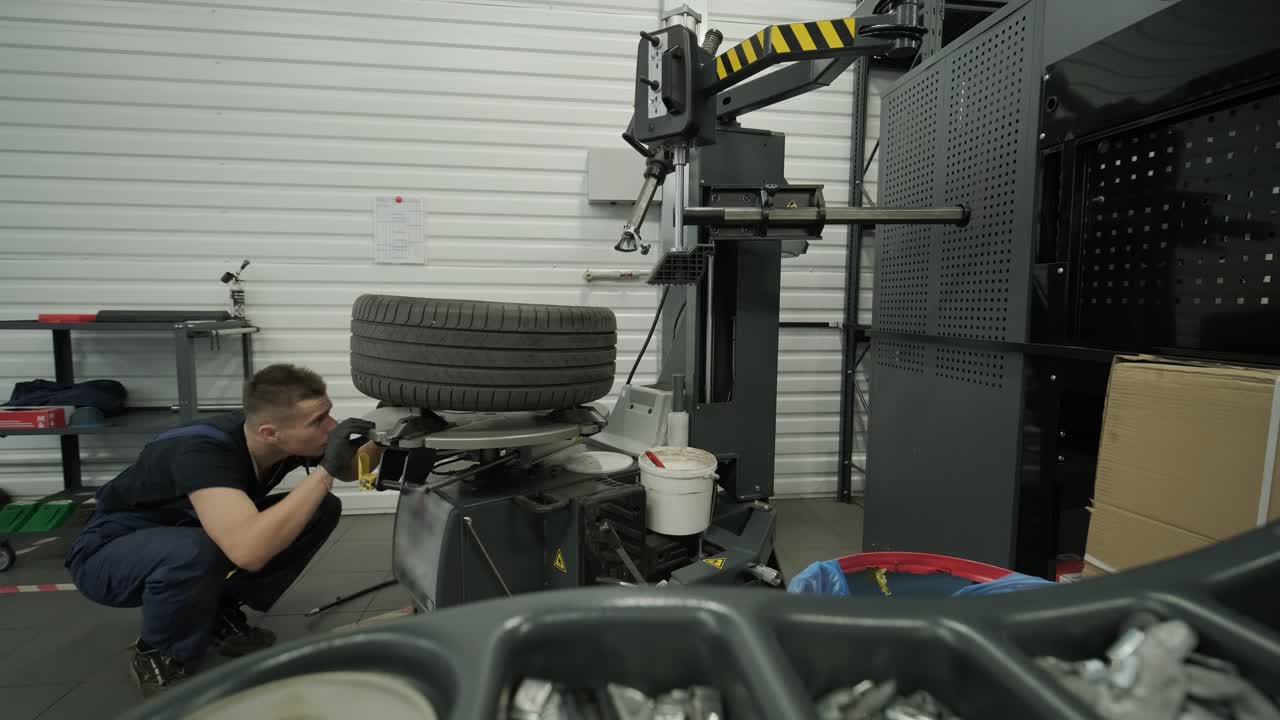 Mechanic working on tire changer in auto repair shop