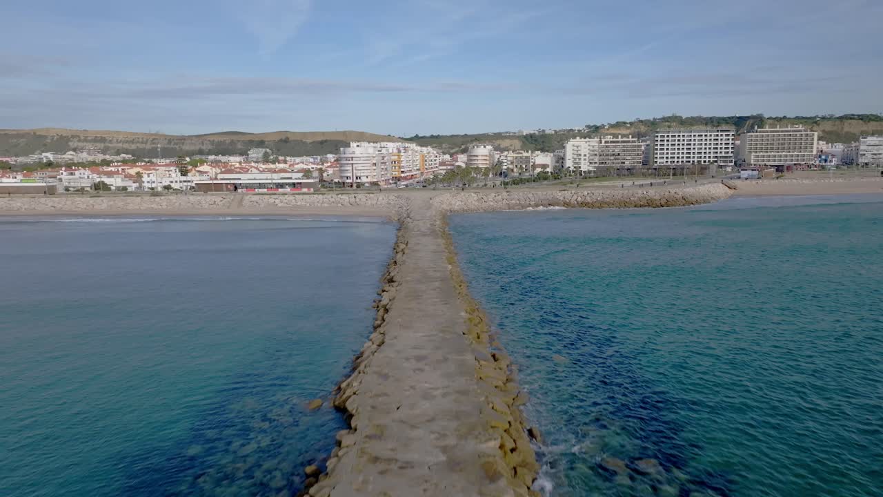 un muelle que rompe las olas en costa da caparica.
