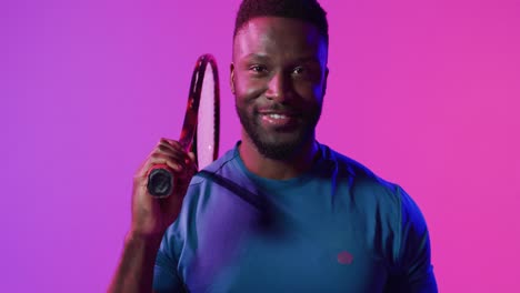 video de un feliz jugador de tenis afroamericano en un relámpago rosa de neón