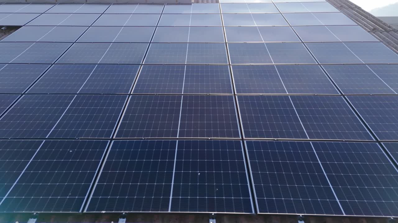 Solar panel units on rooftop of house. Aerial close up shot. Photovoltaic units on top of barn in swiss rural area. Production of cheap energy.