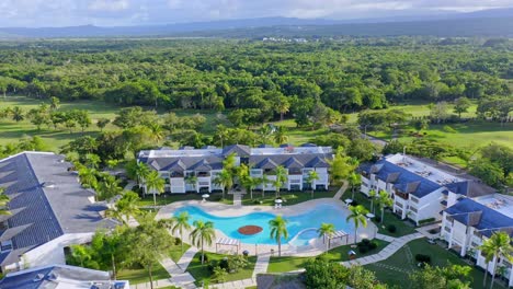 aerial over resort area with pool and palms next to golf course