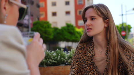 professional psychotherapist providing compassionate counseling to young woman at urban bar table, addressing emotional challenges through supportive dialogue and active listening