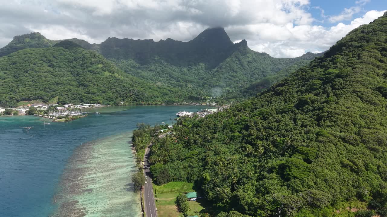 Aerial View of Moorea Island, French Polynesia. Coastal Road, Harbor and Green Rainforest on Volcanic Hills, Drone Shot