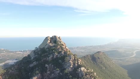 Drone-En-La-Cima-De-La-Montaña-Con-El-Mar-Al-Fondo