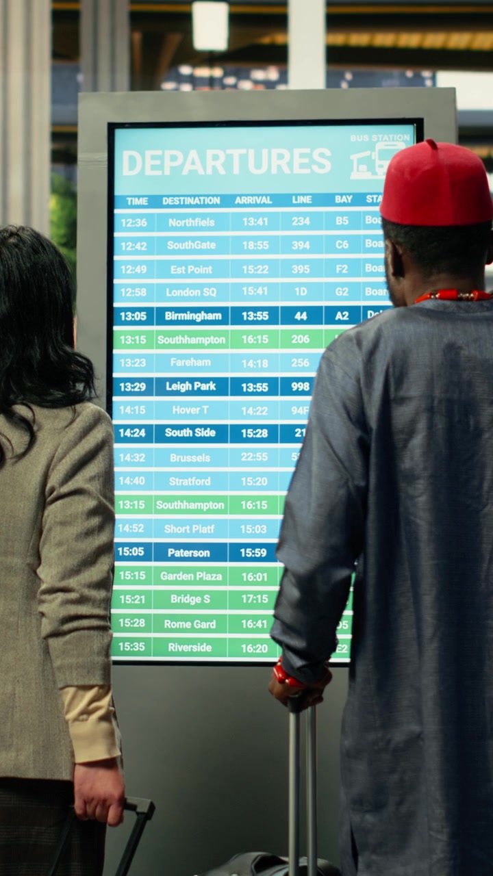 Escena de transporte público que muestra a viajeros consultando la pantalla de horarios.