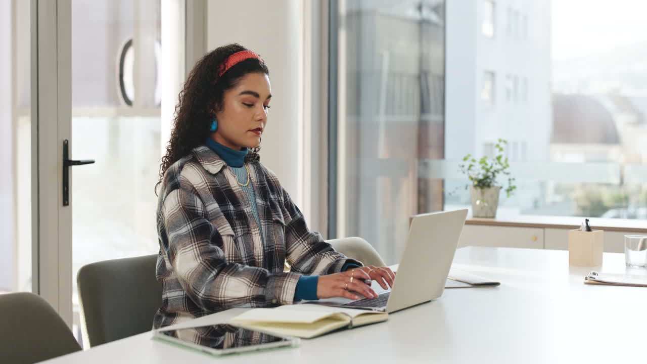 mujer trabajando en una computadora portátil en su escritorio
