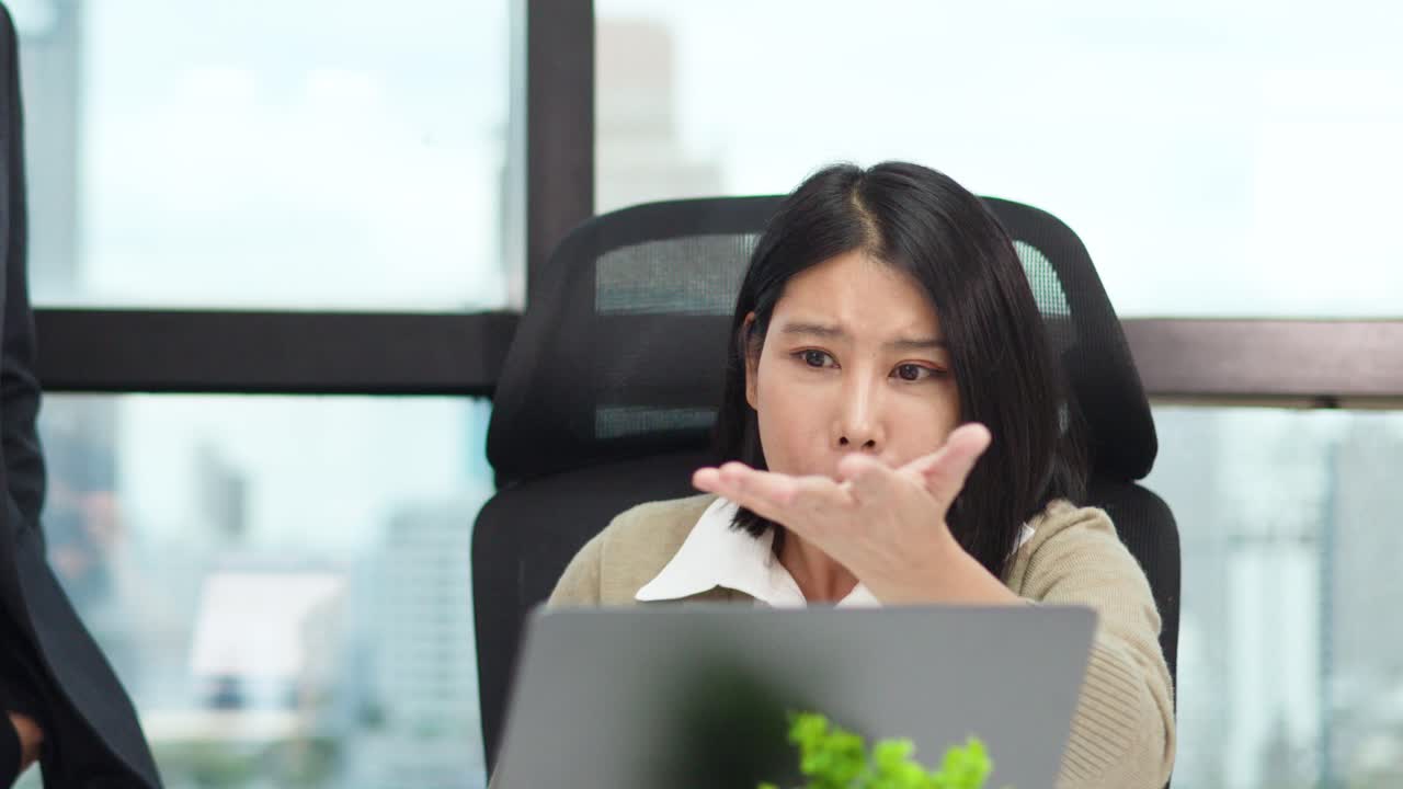 Businesswoman reacts anxiously during tense workplace conversation, natural daylight, static camera, office setting