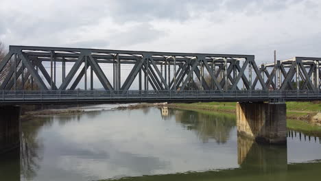 drone flies away from a bridge over the arno river, tuscany region in italy