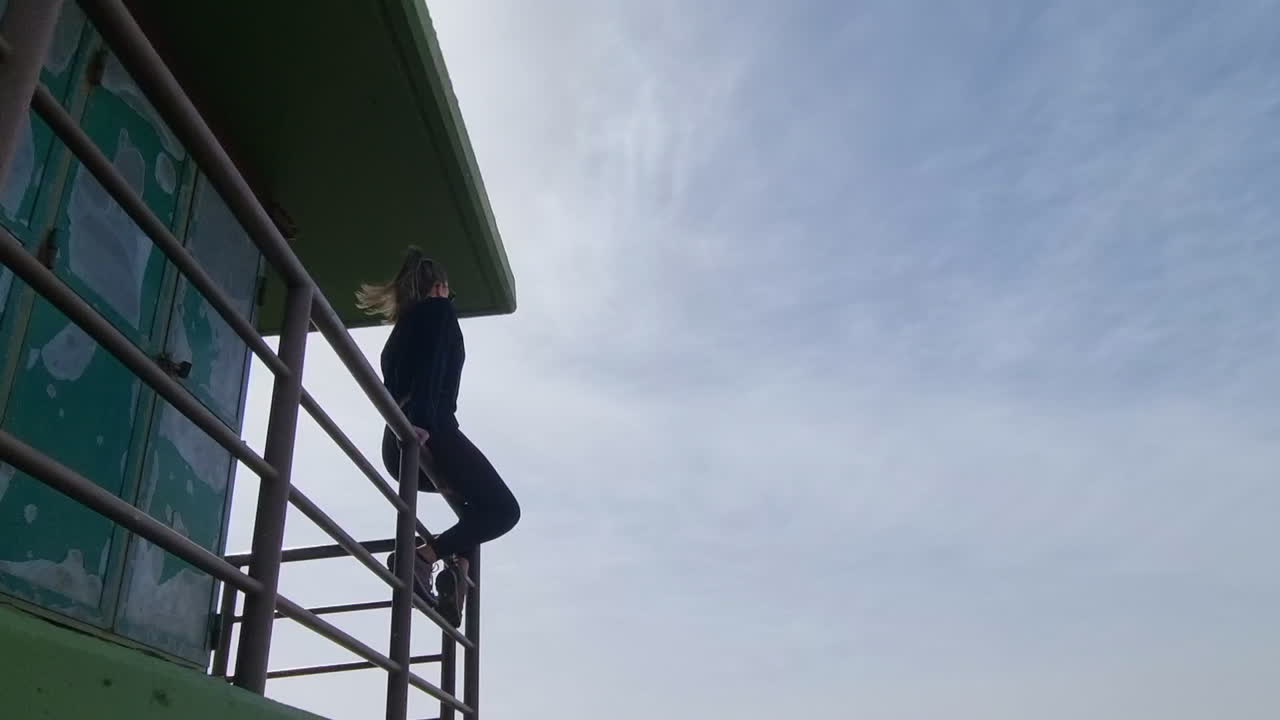 Woman climbing a guard tower railing at Pico de la Gorra, Gran Canaria