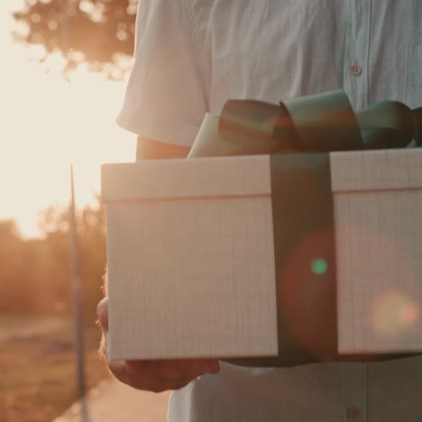 a man carries a box with a gift beautifully packaged with tape 1