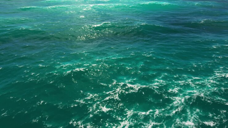 Una scena mozzafiato del mare azzurro che si fonde perfettamente con un cielo mozzafiato adornato da nuvole soffici e gonfie