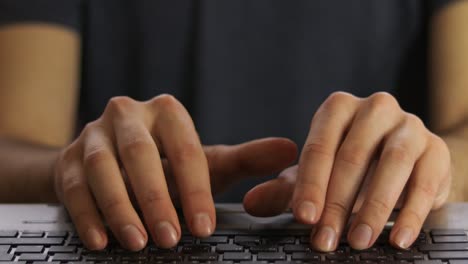 male hands of young man typing on notebook keyboard front view selective focus.