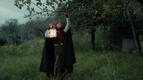 mysterious woman collects fruits to perform esoteric ritual in the countryside