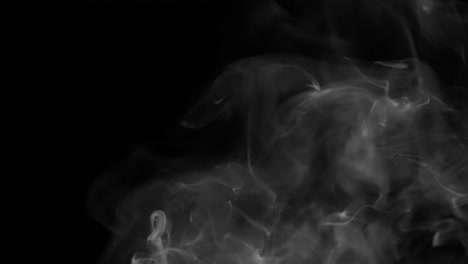 a-heavy-smoke-trail-being-reduced-to-a-small-smoke-trail-isolated-on-a-black-background