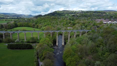 aerial view pontcysyllte aqueduct and river dee canal narrow boat bride in chirk welsh valley countryside slow descending shot