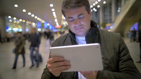 man with tablet pc in airport or railway terminal