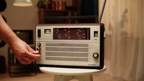 man tuning a vintage radio