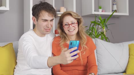 Mother-son-love.-Mother-son-looking-at-phone-and-laughing.