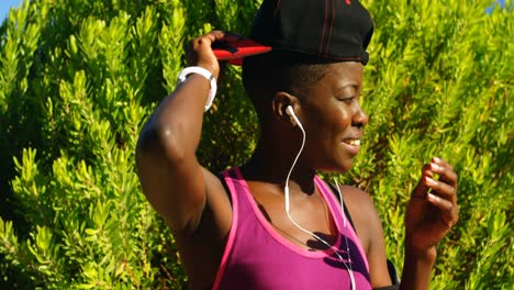 atleta femenina ajustando su gorra en el bosque 4k