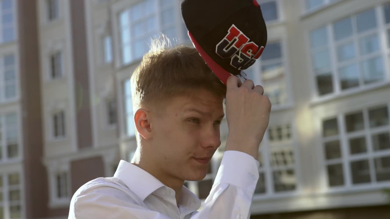 Young Man Adjusting Baseball Cap Outdoors