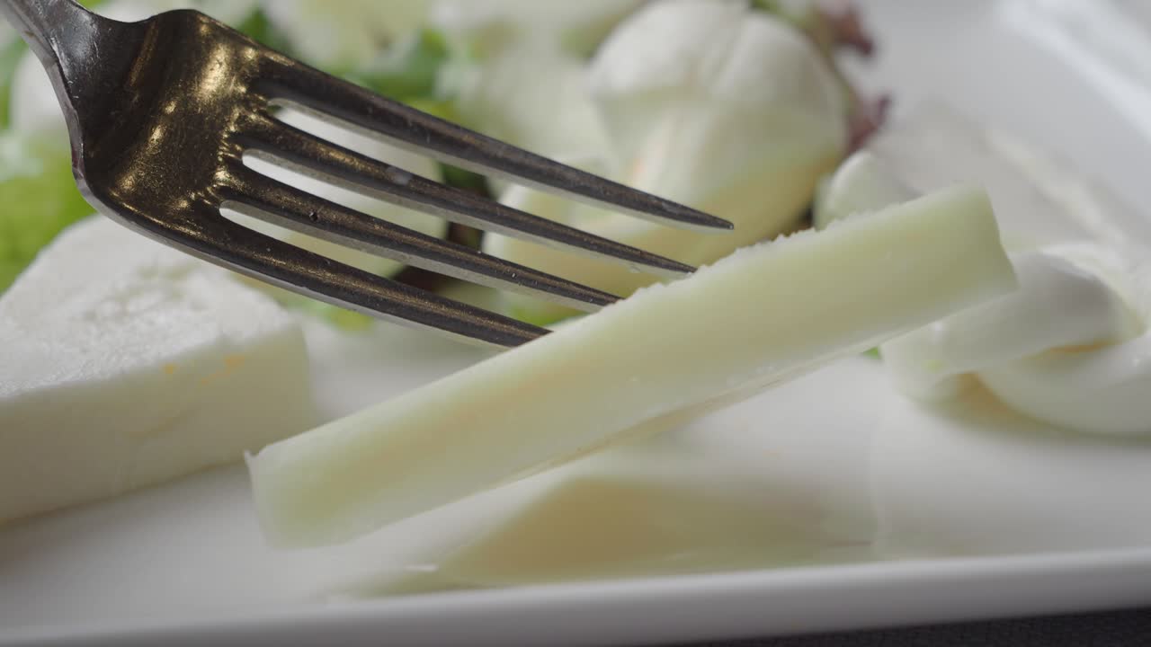 Variety of cheeses with fork on a plate