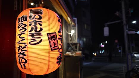 linterna japonesa brillando contra un fondo urbano oscuro