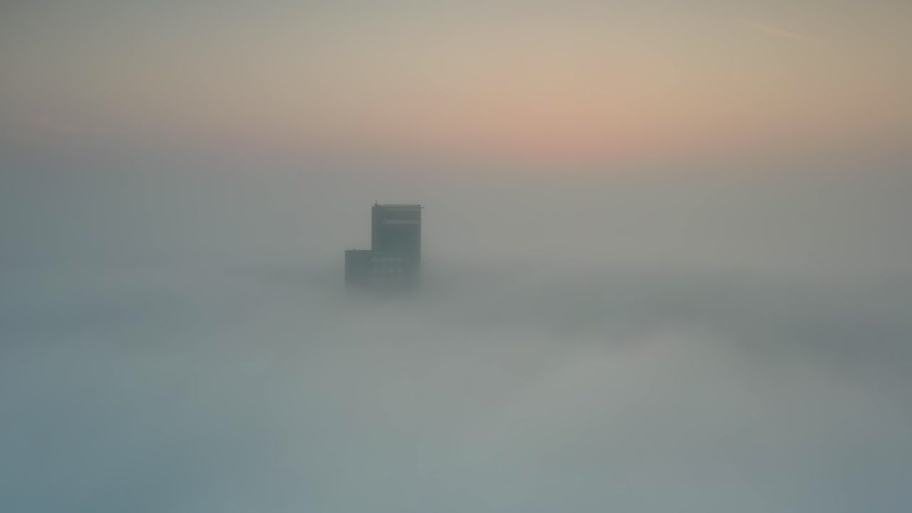 Foggy Sunrise Over City Building