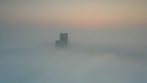 foggy sunrise over city building