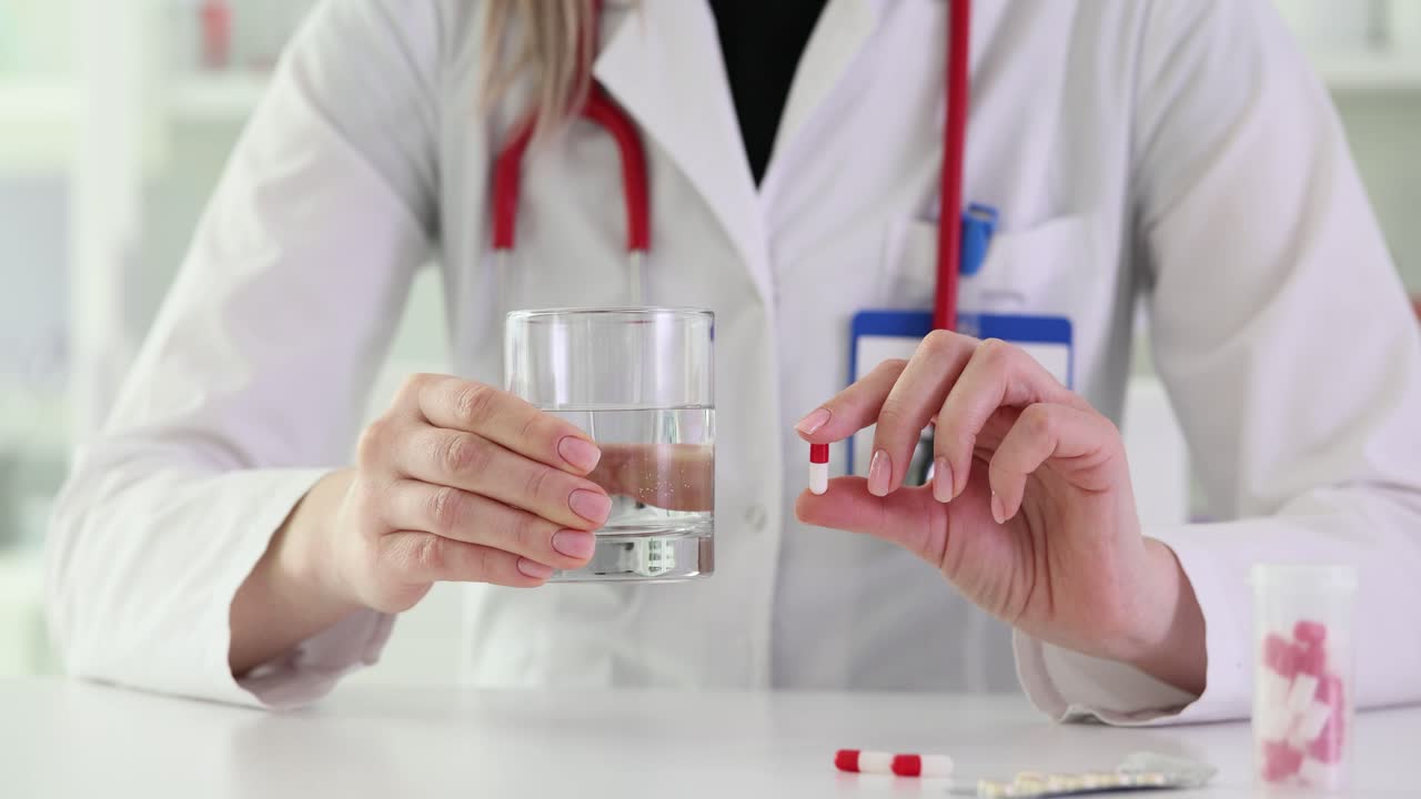Doctor Holding Pill with Glass of Water