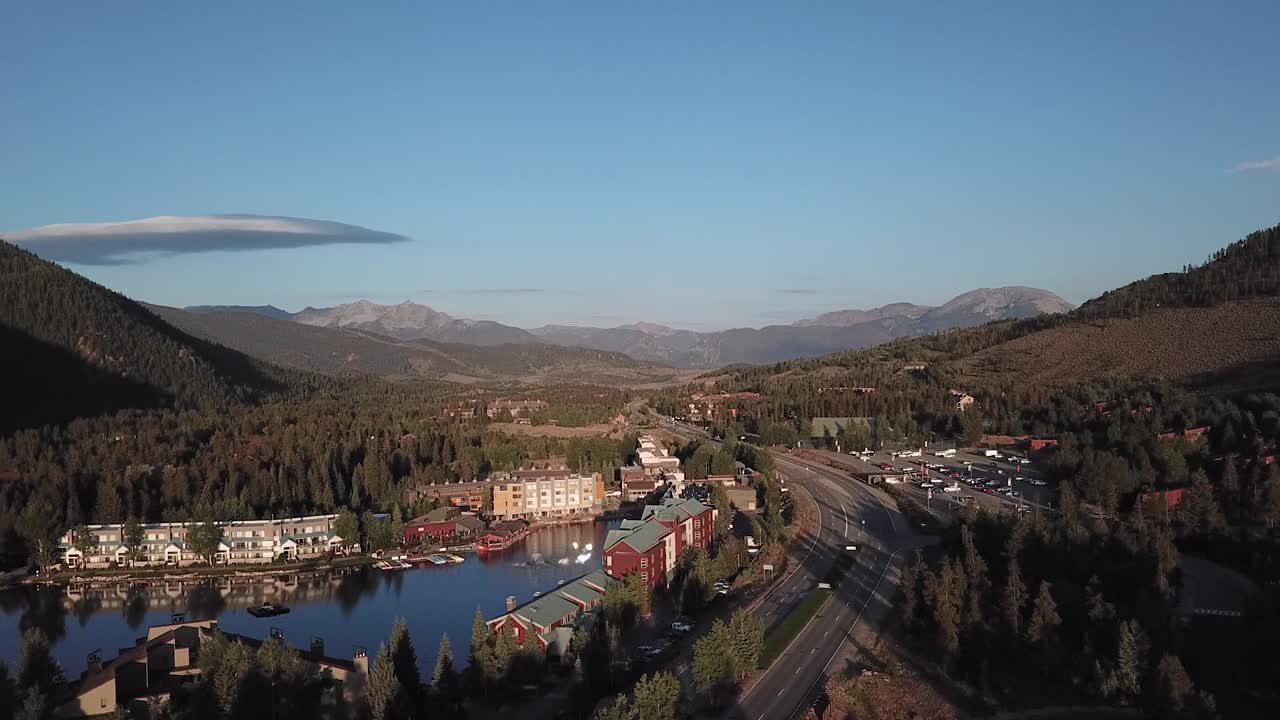 sunset view of village near forest in colorado, aerial drone tilt up shot