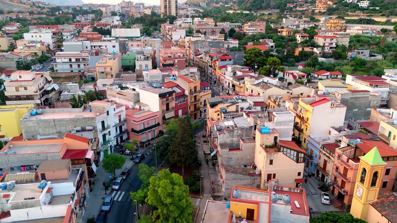 Vista aerea mattutina sui fitti tetti residenziali e sulla vivace architettura del villaggio di Sferracavallo a Palermo, Sicilia, durante l'alba.