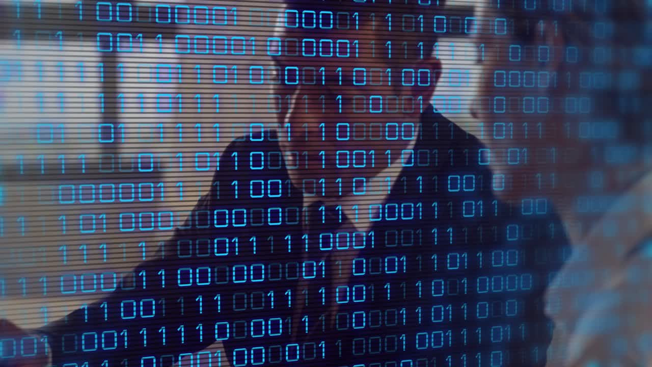 Scrolling binary digits on desk, man writing notes; colleague marking documents in business meeting
