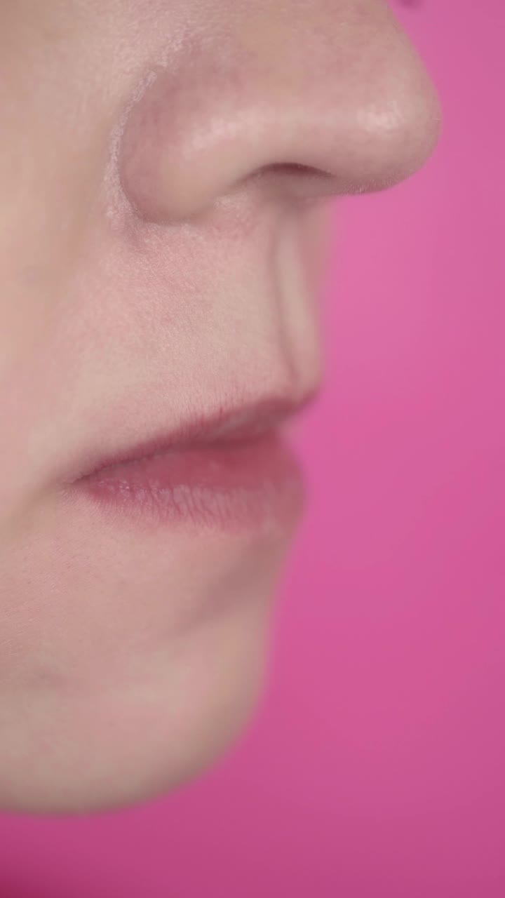 Close-up of Woman Applying Pink Lip Gloss