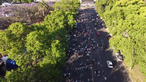 aerial flyover busy road with many argentinian supporters and driving cars on road - crowd walking by the streets of buenos aires city