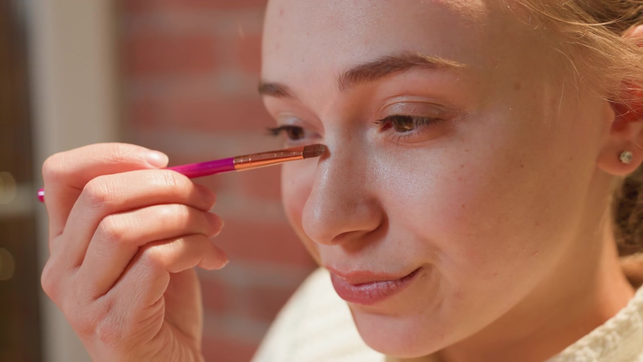 Close-Up of Young Woman Applying Eyeshadow with a Makeup Brush