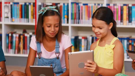 niños de la escuela usando tableta digital en la biblioteca