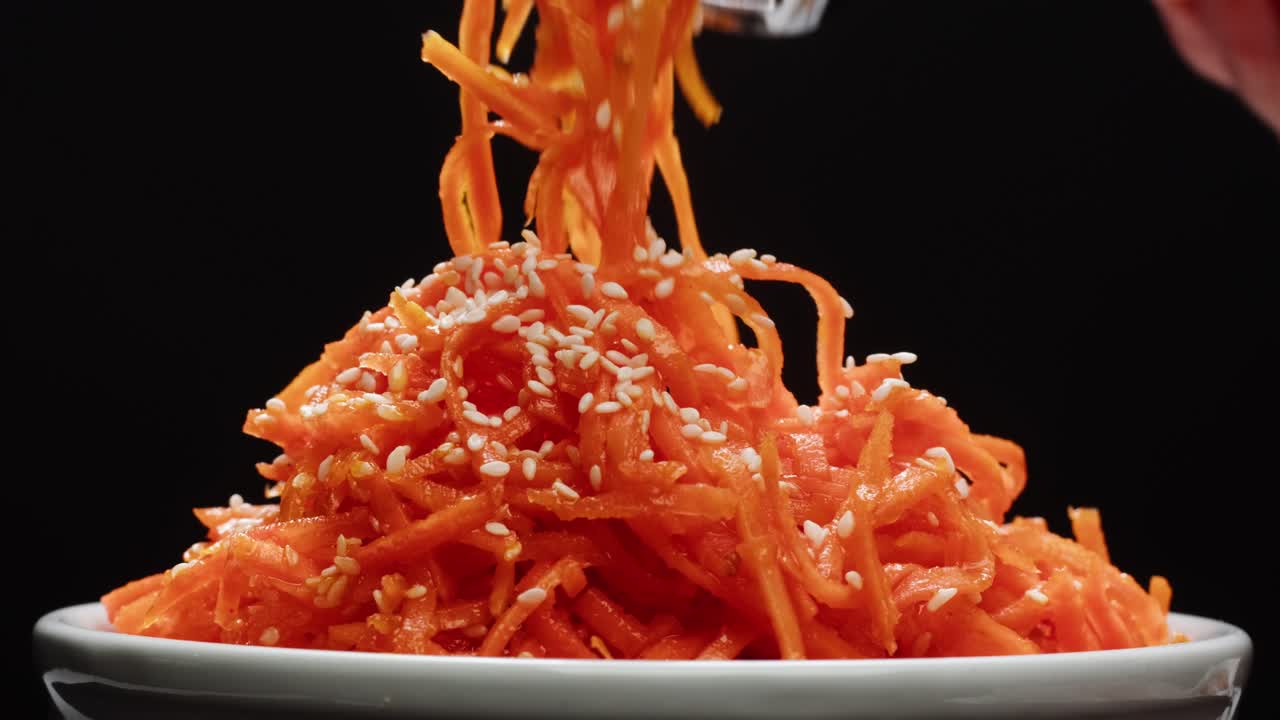 ensalada de zanahorias marinadas fermentadas, zanahorias picadas al estilo coreano, ajo, aceite vegetal y condimentos en una mesa giratoria