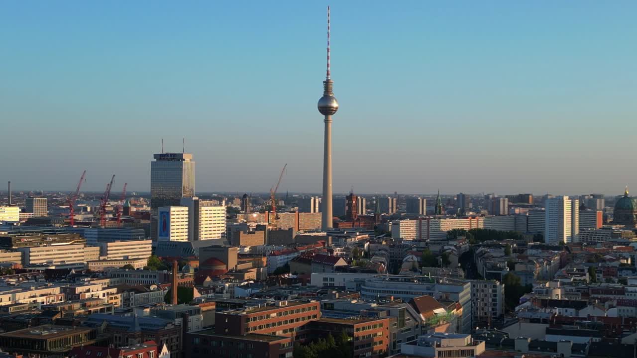 베를린 tv 타워는 타워와 레드 타운 홀 위에 높이 서 있으며, 황금 시간의 따뜻한 빛에 목욕합니다.