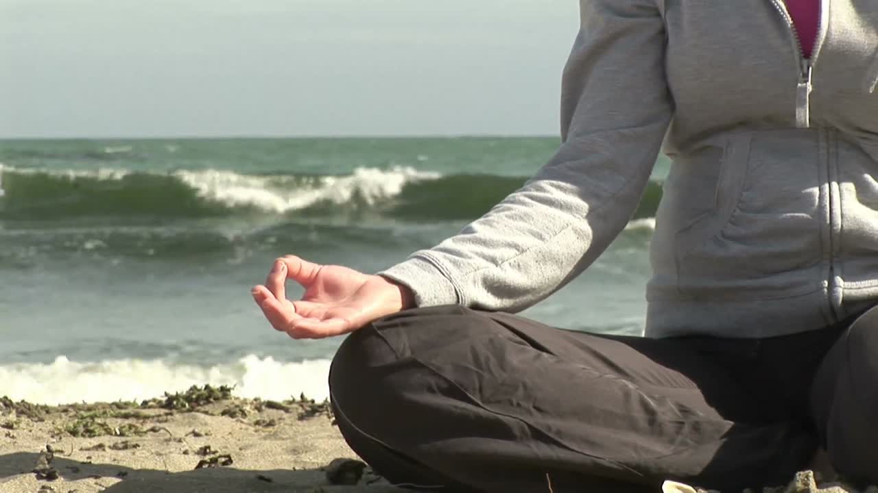 mujer meditando en la playa