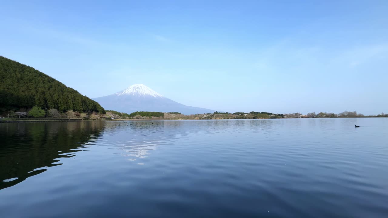 Clear and serene view of Lake Tanuki with Mount Fuji in the background on a calm day