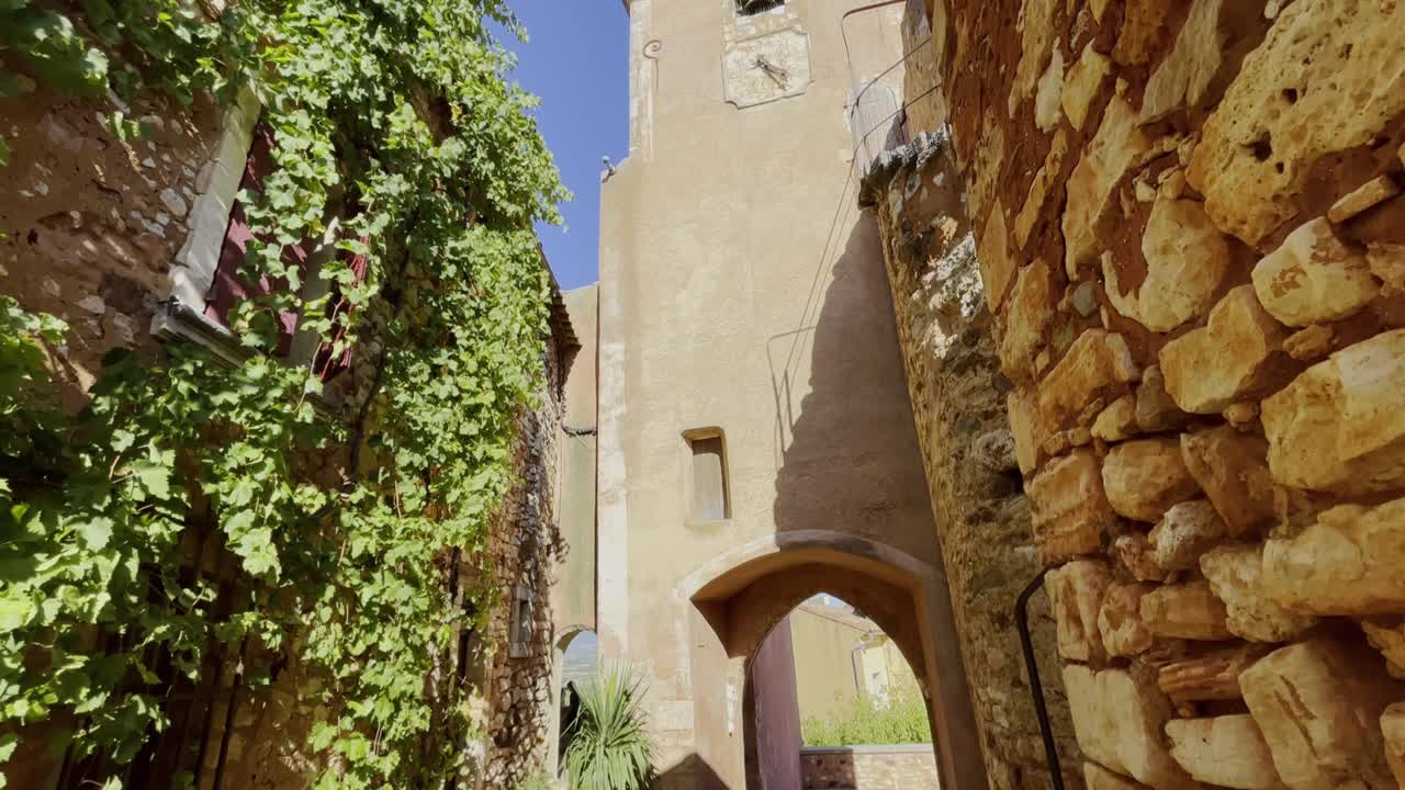 Tower in a village in France in a small village historically made of stone with plants in good weather