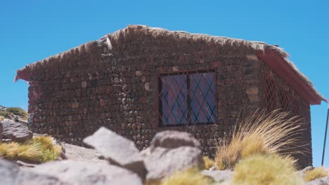 casa de piedra en el desierto al lado del lago rodeado de montañas día de cerca